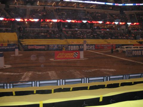 1994 Ford Bronco - Monster Jam event in an indoor arena with multiple vehicles and a large crowd in the stands.