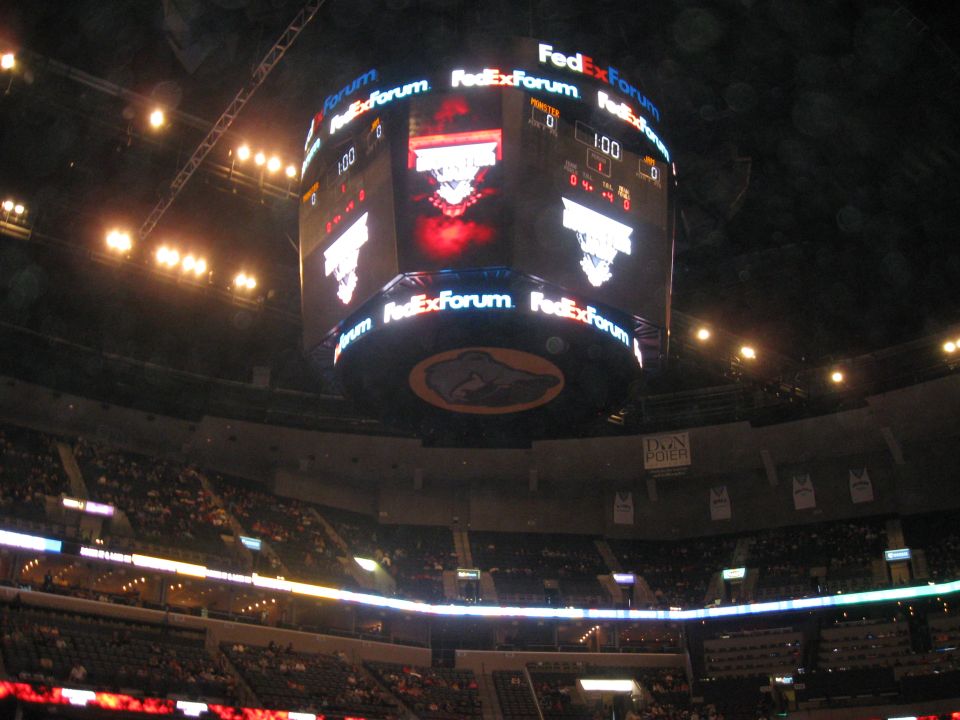 Scoreboard in a dark arena with people in the stands