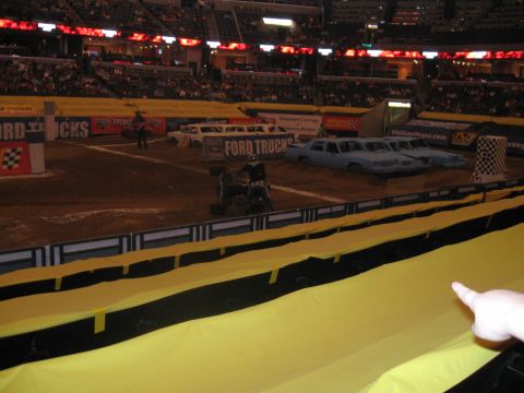 1994 Ford Bronco - Monster truck event with cars lined up as obstacles in an arena. Ford Trucks banner is visible.