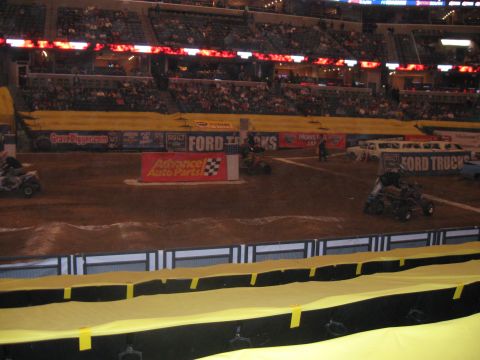1994 Ford Bronco - A Monster Jam event is underway in a stadium with multiple vehicles and sponsor banners visible.