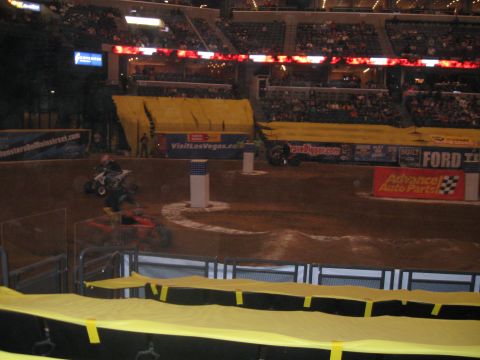 1994 Ford Bronco - Monster truck event in an arena with ATVs on the dirt track and spectators in the stands.