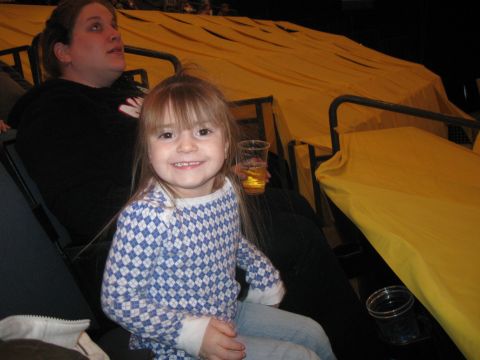 1994 Ford Bronco - A young girl smiles while sitting in stadium seats, with a yellow tarp covering the stands behind her.