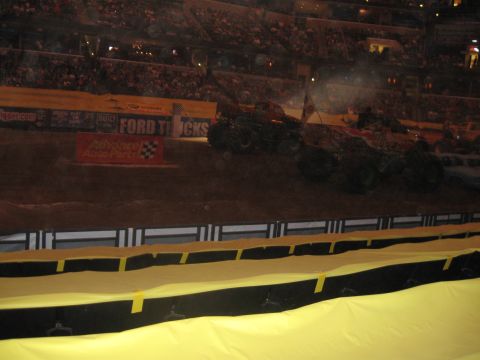 1994 Ford Bronco - Monster trucks compete in a stadium event with a large audience in the stands.