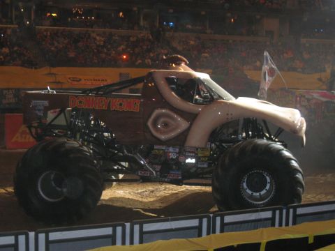 1994 Ford Bronco - A Donkey Kong themed monster truck with a custom body sits on a dirt arena floor.