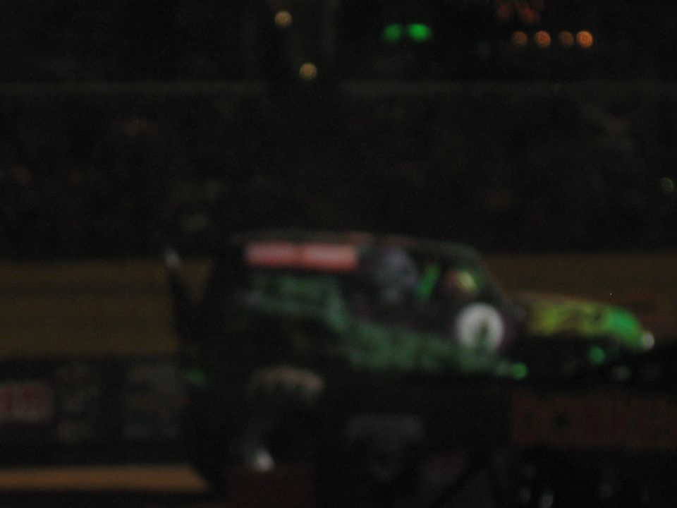 Monster truck with green and black graphics, side view