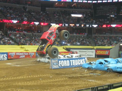1994 Ford Bronco - Monster truck event with multiple crushed cars on the dirt track.