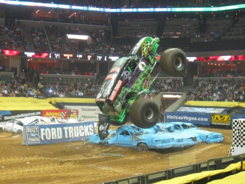 1994 Ford Bronco - A monster truck performs a jump over a line of crushed cars during a Monster Jam event.