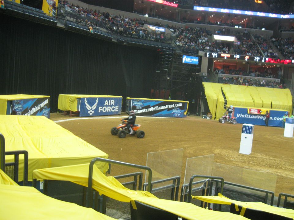 ATV rider in an arena with 'Air Force' and 'MonstersOnMainstreet.com' banners