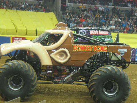 1994 Ford Bronco - A Donkey Kong themed monster truck is shown at an event with a Grave Digger truck in the background.