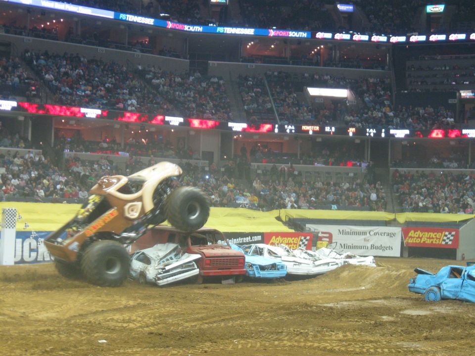 Monster truck jumping over crushed cars in an arena