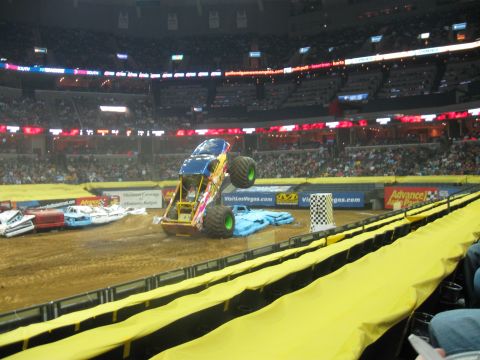 1994 Ford Bronco - Monster truck event with multiple vehicles and spectators in a stadium.
