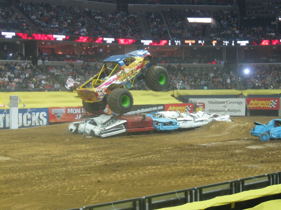 Monster truck airborne over crushed cars