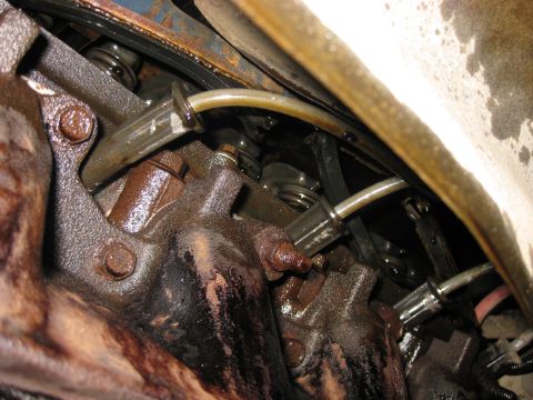 1979 Ford Bronco - This image shows a close-up view of an engine's internal components, specifically the valve train, with visible oil and rust.