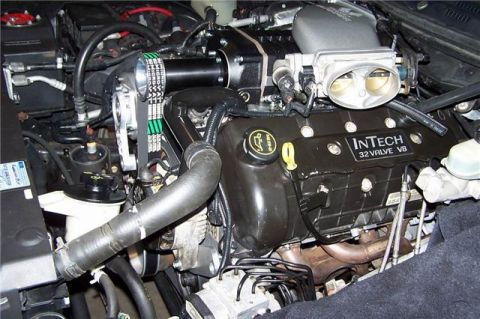 1996 Ford Thunderbird - Close-up view of a supercharged InTech 32 Valve V8 engine with various hoses and components visible.