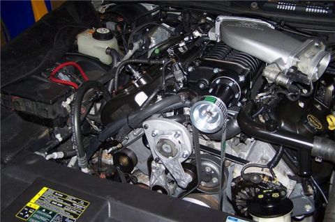 1996 Ford Thunderbird - Close-up view of a modified V8 engine bay a prominent supercharger and custom intake.