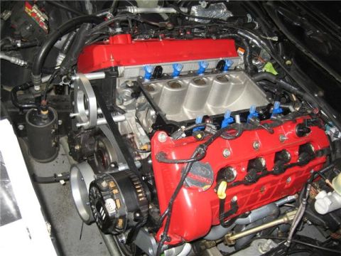 1996 Ford Thunderbird - Close-up of a Ford V8 engine, likely modified, with red valve covers and a silver intake.