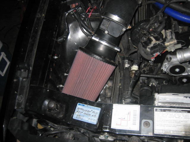 Engine bay with aftermarket air filter and visible Ford label
