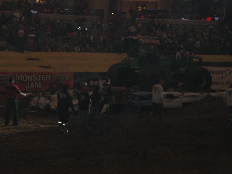 Monster truck on dirt track with crowd in background and "Monster Jam" banner