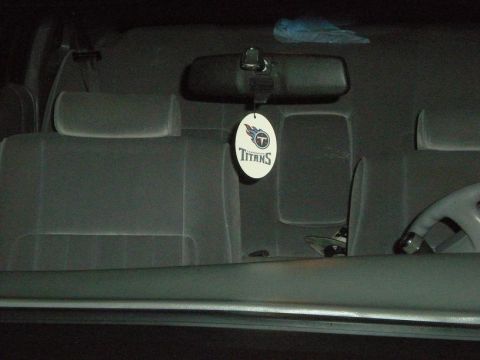 1994 Ford Crown Victoria - The interior of a car is visible, fabric seats and a Tennessee Titans air freshener hanging from the rearview mirror.