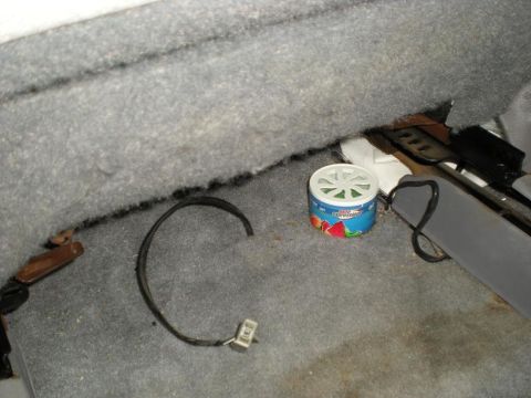 1994 Ford Crown Victoria - A car's interior floor shows a loose wire and a round air freshener with fruit imagery.