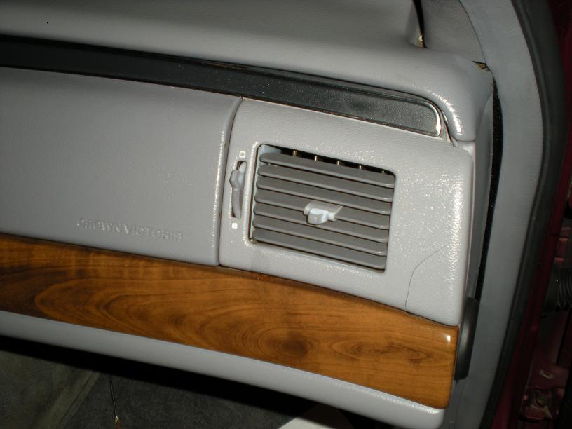 Gray dashboard vent and wood trim with "Crown Victoria" text visible