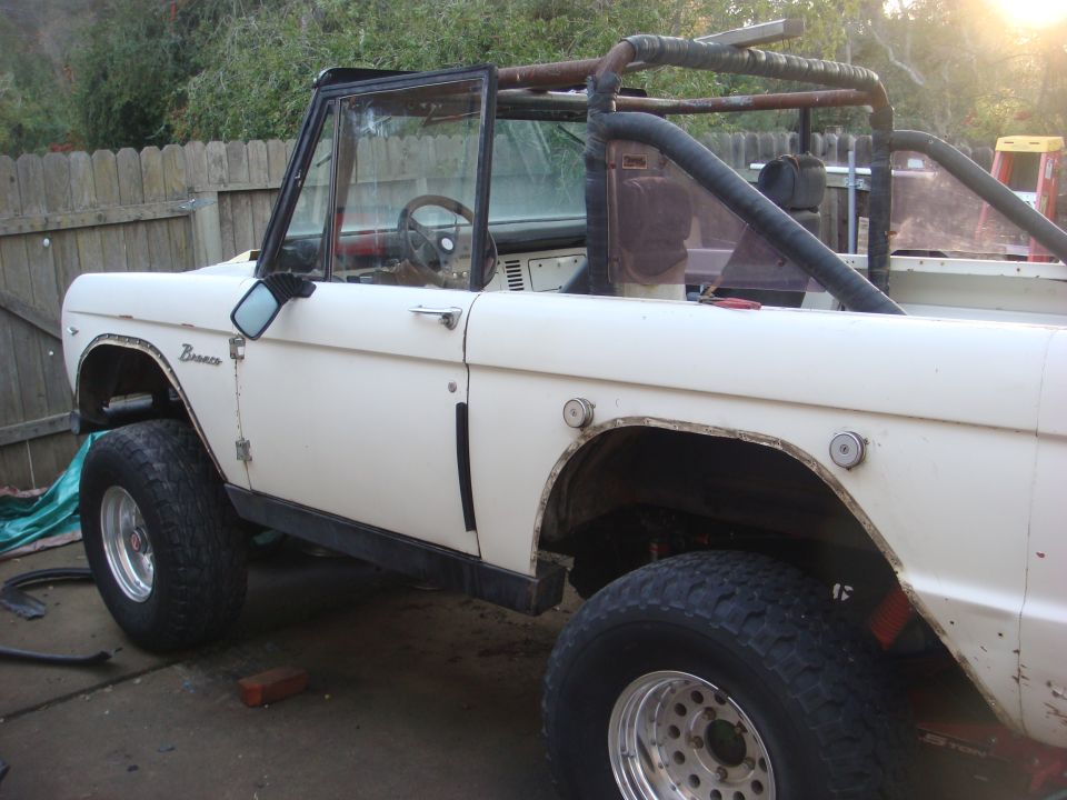 White 1968 Ford Bronco with roll cage and off-road tires