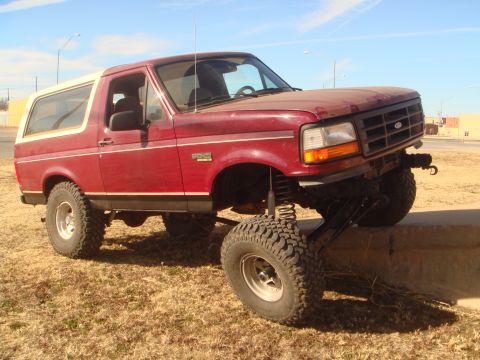 1992 Ford Bronco - This lifted Ford Bronco is positioned with its front right tire on a concrete barrier.