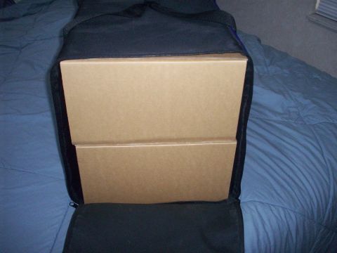 2006 Ford F-150 - Cardboard boxes are placed inside a black bag on a bed.