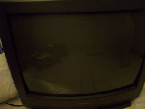 2006 Ford F-150 - A dark television screen reflects the surrounding room, showing a glimpse of what appears to be a box or books.