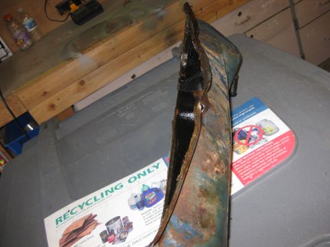 1979 Ford Bronco - A heavily damaged metal component, possibly from a vehicle, shows significant rust and deformation.