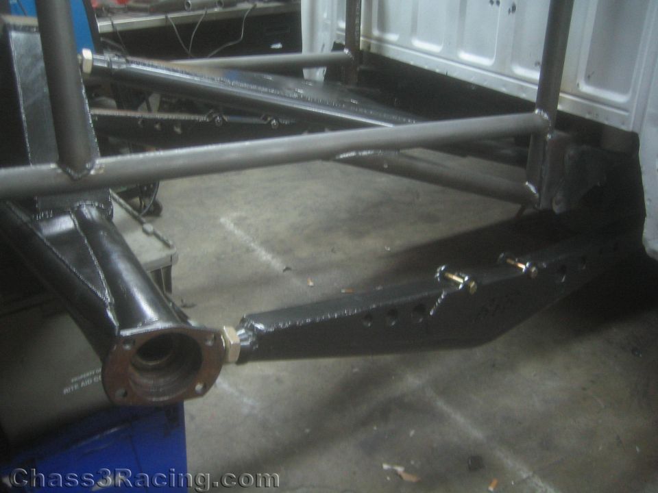 Fabricated tubular suspension link and chassis with flange near concrete floor