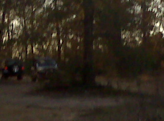 2008 Jeep Wrangler - Two SUVs are seen driving on a dirt road with trees in the background. The registry information may be incorrect.