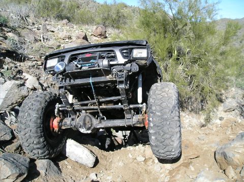 1986 Toyota Hilux - Off-road truck navigating a rocky trail with its front end visible.
