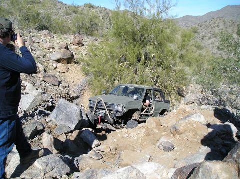 1986 Toyota Hilux - This modified 1986 Toyota Hilux navigates a rocky, off-road trail with a winch and roll cage.