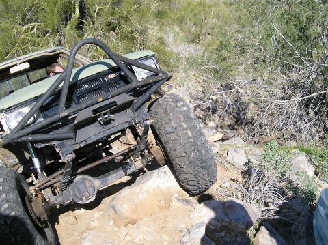 1986 Toyota Hilux - Off-road Toyota truck with a custom roll cage is shown on a rocky trail.