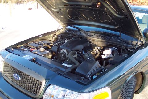 2001 Ford Crown Victoria - The engine bay of a Ford Crown Victoria is shown with the hood open, revealing the engine and surrounding components.