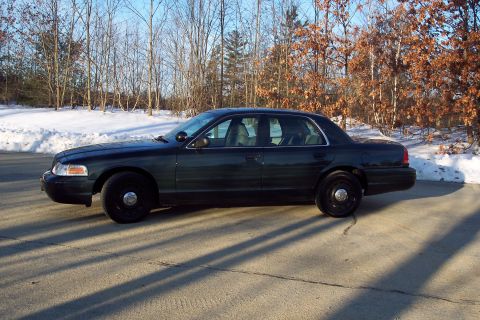 2001 Ford Crown Victoria - Side view of a dark 2001 Ford Crown Victoria sedan parked outdoors in winter.