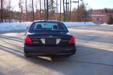 2001 Ford Crown Victoria - Rear view of a black 2001 Ford Crown Victoria parked in a lot with snow on the ground.
