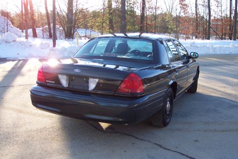 2001 Ford Crown Victoria - Rear view of a dark Ford Crown Victoria sedan parked outdoors in winter.