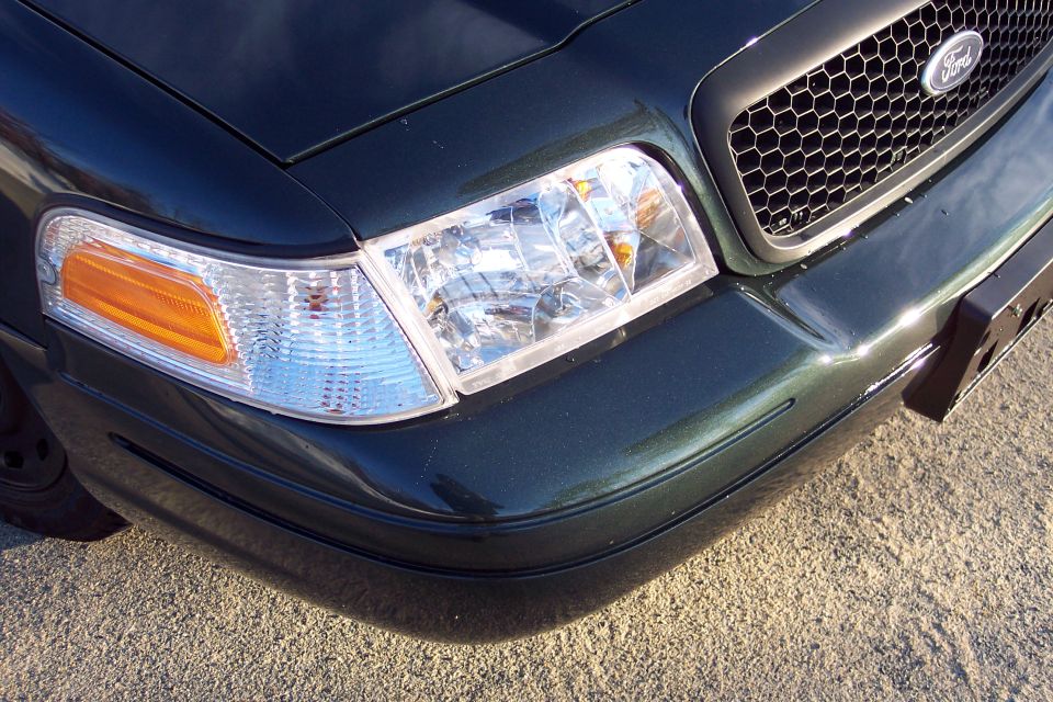 Dark green 2003 Ford Crown Victoria front corner with honeycomb grille and clear headlights