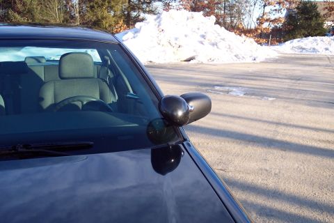2001 Ford Crown Victoria - Interior view of a police car, including the steering wheel and side mirror, with snow piles in the background.