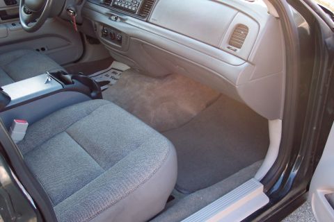 2001 Ford Crown Victoria - Interior view of a police car, showing the dashboard, seats, and floor mats. The registry claims it is a 2001 Ford Crown Victoria, but this…