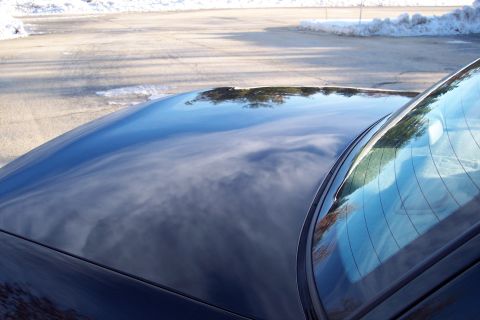 2001 Ford Crown Victoria - Reflection on a car's hood and windshield on a sunny day with snow on the ground.