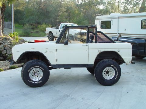 1968 Ford Mustang - A white Ford Bronco is parked in a driveway with other vehicles visible in the background.