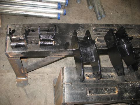 1995 Ford C-350 (Centurion Conversions) - Painted suspension parts and galvanized pipes are laid out on a workbench.
