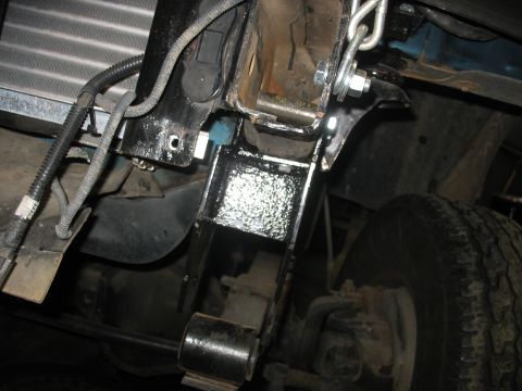 1995 Ford C-350 (Centurion Conversions) - Close-up view of a vehicle's suspension system, showing a leaf spring and mounting hardware.