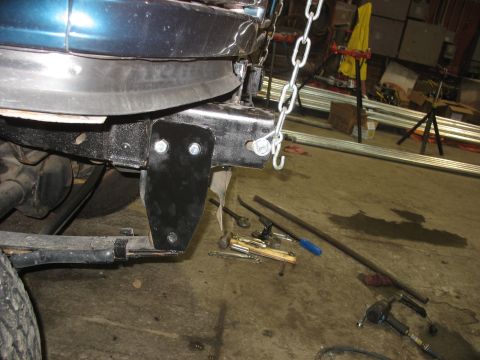 1995 Ford C-350 (Centurion Conversions) - A custom bracket is being installed on the vehicle's frame, possibly for suspension modification.