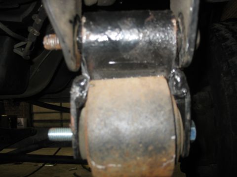 1995 Ford C-350 (Centurion Conversions) - A close-up view of a suspension component, likely a bushing, showing signs of rust and wear.
