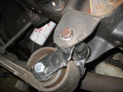 1995 Ford C-350 (Centurion Conversions) - Close-up view of a vehicle's suspension part and an oil filter, likely taken during maintenance or repair.
