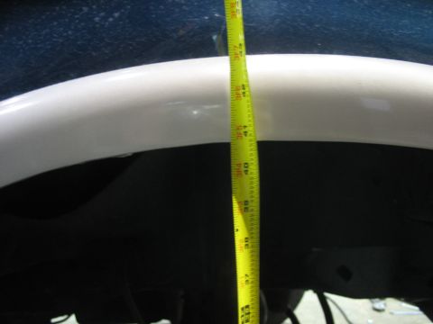 1995 Ford C-350 (Centurion Conversions) - Close-up of a white wheel well arch with a tape measure indicating clearance.